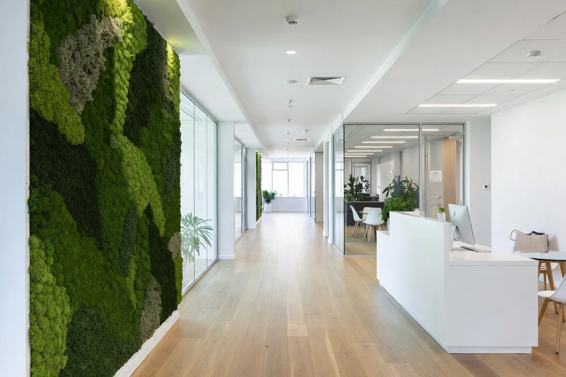 Bright reception corridor with a full-height preserved moss wall